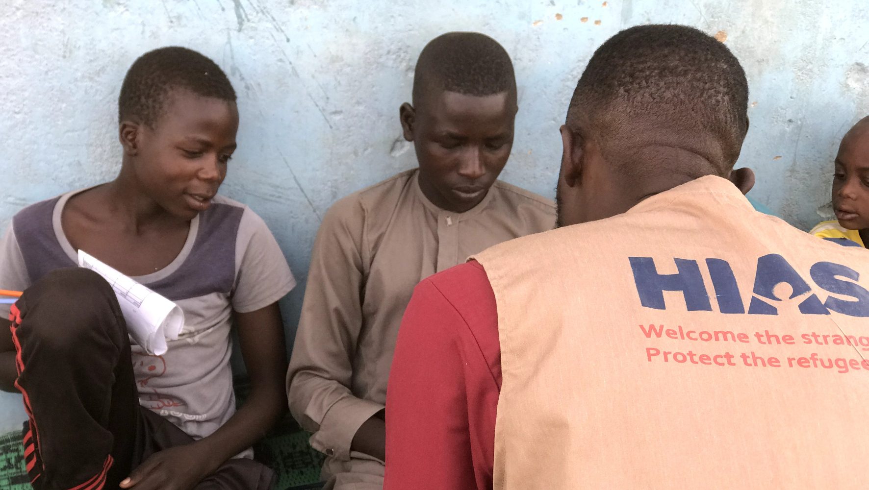 A HIAS worker talks to children at a refugee camp in Chad.